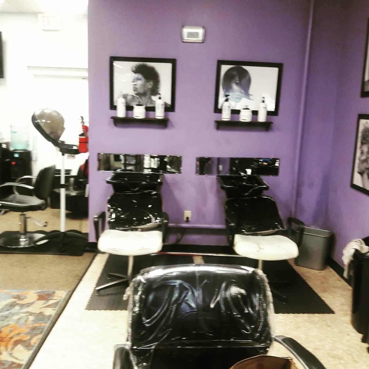 Shampoo chairs against the purple wall inside the salon